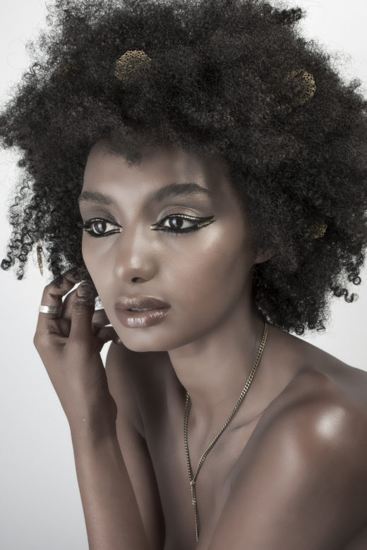 Gold eyeliner beauty shot on black skin model